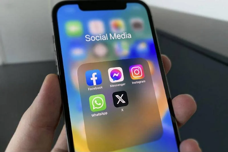 Hand holding a phone with social media apps