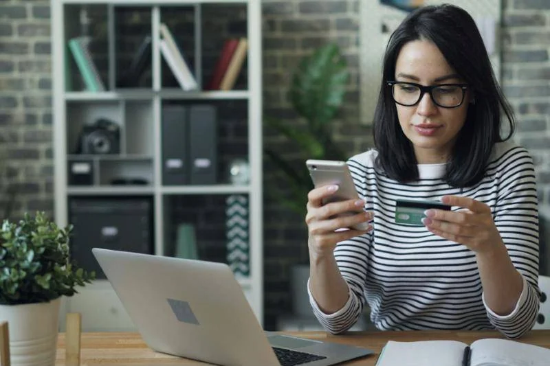 Shopper paying online with a card and phone